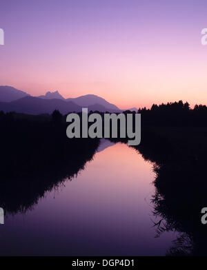 Le montagne si riflette nel Hopfensee lago Achen dopo il tramonto, Ostallgaeu distretto, Bavaria Foto Stock