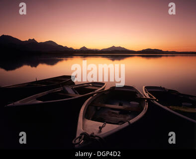 Barche a remi sul Lago Hopfensee dopo il tramonto, Ostallgaeu distretto, Bavaria Foto Stock