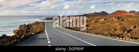 Strada sulla costa ovest attraverso un paesaggio vulcanico, Lanzarote, Isole Canarie, Spagna, Europa Foto Stock