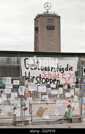 Manifesti di protesta contro la Stuttgart 21 progetto ferroviario su una recinzione del sito, torre della vecchia stazione ferroviaria sul retro, Schlossgarten Foto Stock