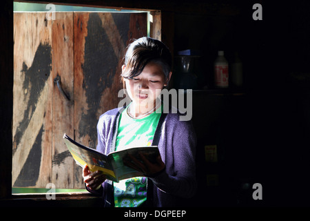 Tribù Angami studente in piedi nella finestra, Zalukie village, Nagaland, India. Foto Stock