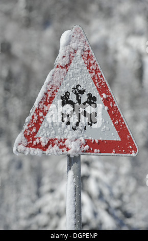Segnale di avvertimento per la neve e il ghiaccio sulla strada Foto Stock