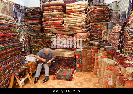 Uomo in un tappeto dealer store, Kemeralti, Izmir, İzmir Provincia, Regione del Mar Egeo, Turchia Foto Stock