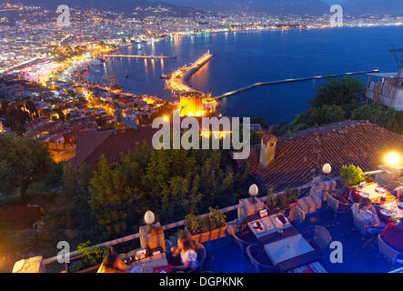 Centro storico della città di Alanya con il porto e Kızıl Kule o Torre Rossa, ristorante sulla collina del castello, Alanya, Riviera turca Foto Stock