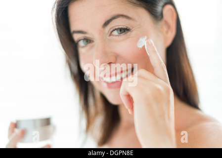 Ritratto di una bella donna matura prevenire le rughe mediante una lussuosa lozione viso Foto Stock