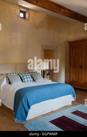 Camera da letto in stile rustico con francese armadio in legno e letto con Jane Saachi coperta Foto Stock