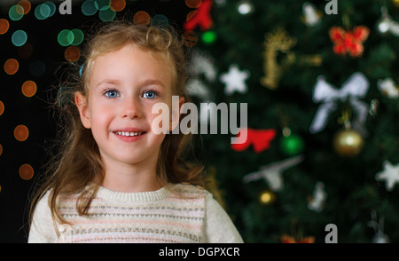 Poco sorridente ragazza decorazioni di Natale Foto Stock