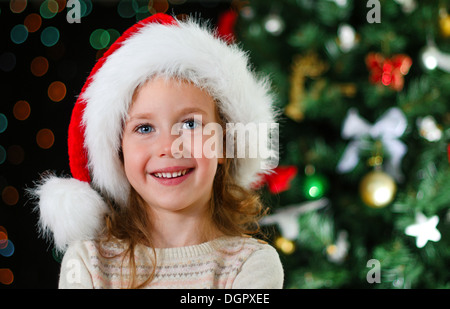 Bambina santa's hat su albero di natale Foto Stock