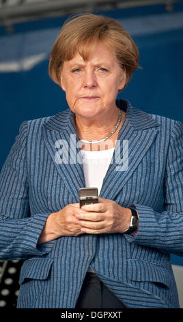 (FILE) un file foto datata 29 agosto 2011 mostra il Cancelliere tedesco Angela Merkel (CDU) con il suo telefono cellulare in una campagna elettorale evento a Rostock, Germania. Foto: Stefan Sauer/dpa Foto Stock