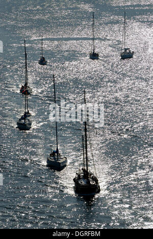 Barche a vela e barche a motore in luce posteriore Foto Stock