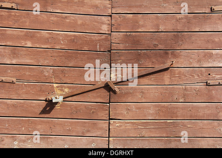 Ferro vecchio arrugginito, fermo sulla vecchia porta di legno Foto Stock