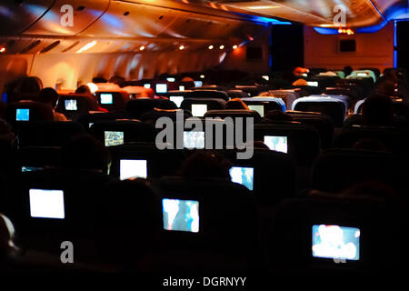 Boeing 777, Classe Economica, l'intrattenimento a bordo di aeromobili di notte Foto Stock