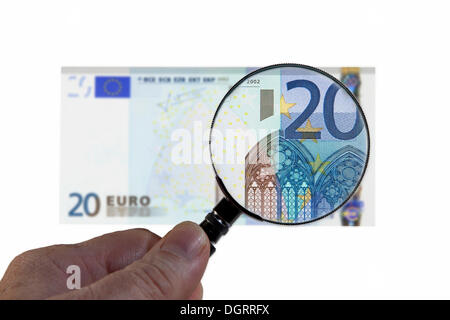 20 di banconote in euro al di sotto di una lente di ingrandimento immagine simbolica, osservazione dell'euro Foto Stock