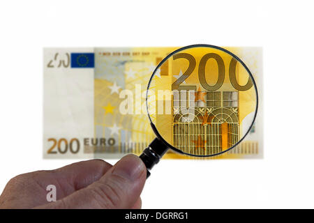 200 di banconote in euro al di sotto di una lente di ingrandimento immagine simbolica, osservazione dell'euro Foto Stock