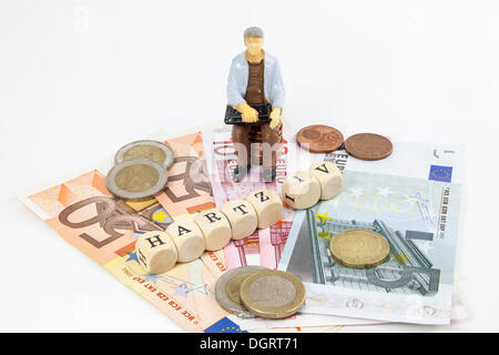 Figura in miniatura di un lavoratore, le banconote in euro, lettera cubi formanti la parola 'Hartz IV' tedesco il sostegno al reddito sovvenzione, simbolico Foto Stock