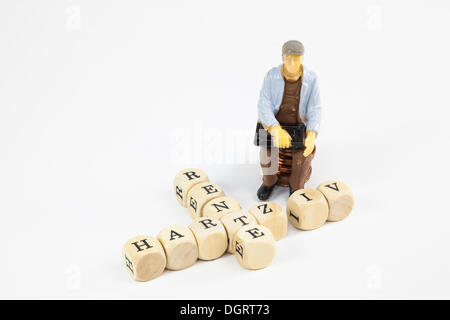 Figura in miniatura e lettera di cubi, lavoratore ricevere Hartz IV tedesco il sostegno al reddito sovvenzione, immagine simbolica per Hartz IV Foto Stock