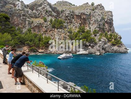 I turisti osservare il traghetto nella baia di La Calobra, montagne Tramuntana, Maiorca, isole Baleari, Mare mediterraneo, Spagna Foto Stock