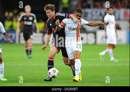 Leverkusen, Germania. 23 Ott, 2013. Leverkusen il figlio Heung-Min (L) il sistema VIES per la palla con Shakhtar Donetsk's Douglas Costa durante la Champions League gruppo un match tra Bayer 04 Leverkusen e FC Shakhtar Donetsk al BayArena a Leverkusen, Germania, 23 ottobre 2013. Foto: Frederic Scheidemann/dpa/Alamy Live News Foto Stock