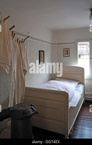 Camera da letto di inizio XX secolo con un letto, un ventre gonfio stufa e una linea bucato sulla sinistra, industrial museum, Lauf Foto Stock