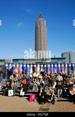 Frankfurt Book Fair, i visitatori di fronte ad una promozione per Brockhaus enciclopedia in Fiera, dietro il Messeturm Foto Stock