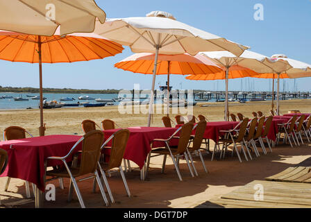 Gli ombrelloni in Rio Piedras river, bar e ristorante, terrazza presso la spiaggia di El Rompido, Cartaya, Costa de la Luz Foto Stock