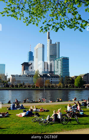 La gente sulla riva del fiume Main, Schaumain Kai, Museumsufer, nella parte anteriore della skyline di ufficio finanziario e Foto Stock