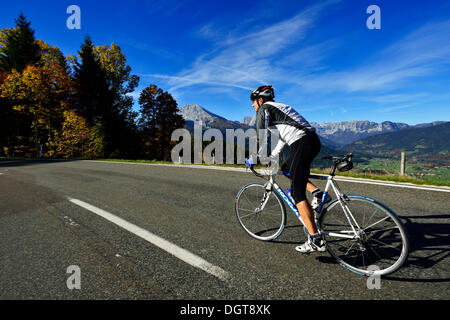 Ciclista a cavallo lungo la Obersalzbergstrasse, Monte Watzmann, Berchtesgaden, Alta Baviera, Baviera Foto Stock