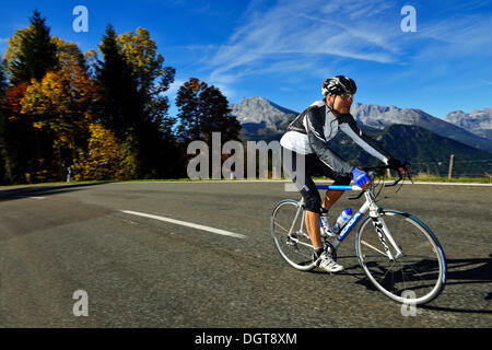 Ciclista a cavallo lungo la Obersalzbergstrasse, Monte Watzmann, Berchtesgaden, Alta Baviera, Baviera Foto Stock