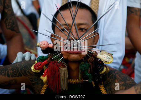 Ma-Thong (medium spiritoso) in trance con guance perforate con lunghi aghi durante il Festival vegetariano di Phuket, città di Phuket, Thailandia. © Kraig Lieb Foto Stock