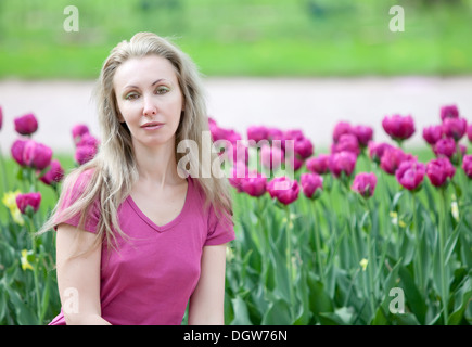 La donna nella primavera del parco con la fioritura tulipani Foto Stock