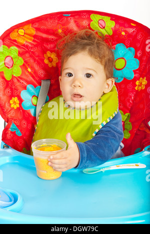 Bambino seduto in poltrona e di essere pronto per mangiare la purea di verdure Foto Stock