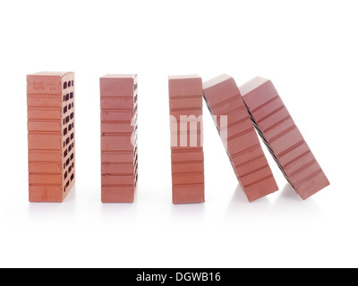 Linea di mattoni rossi con il primo mattone nella caduta successiva rendendo un effetto domino shot su bianco Foto Stock