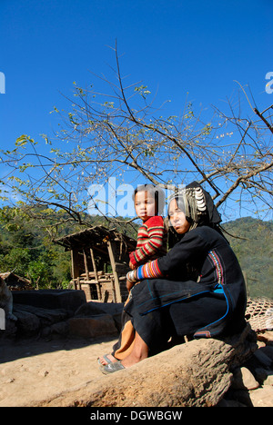 La madre e il bambino, giovane donna Akha Pixor gruppo etnico, costume tradizionale, abbigliamento tradizionale, colore indaco Foto Stock