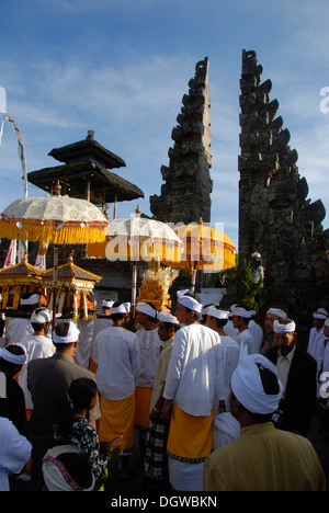 L Induismo Balinese, la raccolta dei credenti, cerimonia, i credenti nel tempio-abito con ombrelloni, split gate, Candi bentar Foto Stock