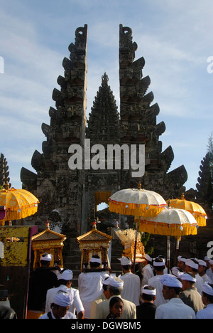 L Induismo Balinese, la raccolta dei credenti, cerimonia, i credenti nel tempio-abito con ombrelloni, split gate, Candi bentar Foto Stock