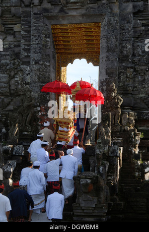 L Induismo Balinese, la raccolta dei credenti, cerimonia, i credenti nel tempio bianco-abito e che red ombrelloni entrante attraverso il Foto Stock