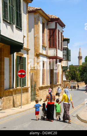 Storica architettura turca con finestre a baia, vicolo del centro storico con un minareto, famiglia turco sul Foto Stock