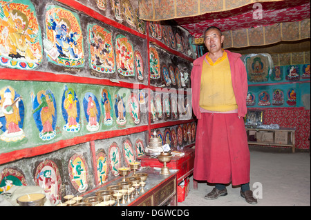 Buddismo tibetano, monaco in una stanza con dipinto luminosamente rock rilievi, Gossul Gompa monastero sopra il lago Manasarovar Foto Stock