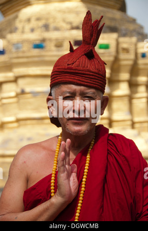 Il Buddismo Theravada, stupa dorato, benedizione, monaco in vesti di colore rosso e tappo, che Xieng Tung, Muang cantare, Luang Namtha Provincia Foto Stock