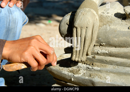 Il Buddismo Theravada, scalpellino, lavorando su un delicato dettaglio, mano di una statua del Buddha, Wat Xayaphoum tempio, Savannakhet, Laos Foto Stock