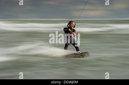 Kitesurfer cavalcando le onde, panning shoot Foto Stock