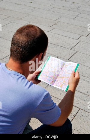 Giovane uomo la lettura di una mappa della città di Essen Capitale Europea della Cultura 2010, la zona della Ruhr, 'Metropole Ruhr', Renania settentrionale-Vestfalia Foto Stock