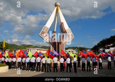 Sfilata, i portabandiera, giovani del Laos Organizzazione della gioventù giovani del Laos con molte bandiere colorate in piedi intorno a un comunista Foto Stock