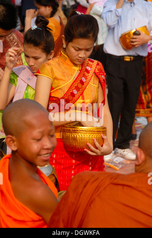 Il Buddismo Theravada, That Luang Festival, Tak Bat, novizio, i monaci ricevono elemosina, il laotiano credente con saliscendi e alms ciotola Foto Stock