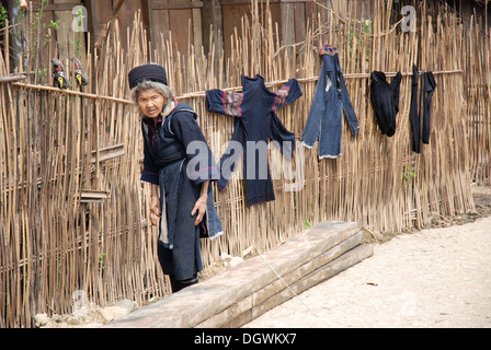 Anziani nero tribù hmong donna appendere fuori servizio lavanderia in Cat cat villaggio nei pressi di Sapa in Vietnam Foto Stock