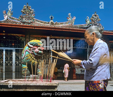 Donna anziana con incenso, offerte, Kuan Yin, il tempio Cinese, Georgetown, Penang, Malaysia Foto Stock