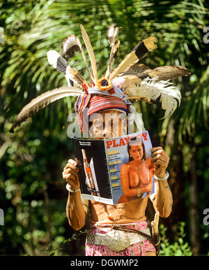 Hinters testa del gruppo etnico di Iban persone leggendo una rivista Playboy, Skrang River, Rajang, Sarawak, Malesia, Borneo Foto Stock