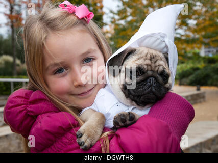 Manchester, Regno Unito 26 ottobre, 2013. Libby McCoy, 7 anni da Chorley, con il suo cucciolo pug Nigel in costume, presso le banchine, Trafford Park, Manchester Open Weekend. Foto Stock