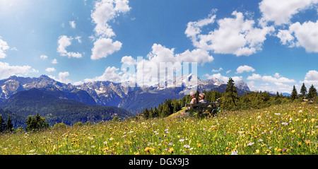 Gli escursionisti seduta su una panchina, prato verde sulla montagna Eckbauer, Eckbauer, Garmisch-Partenkirchen, Alta Baviera, Baviera, Germania Foto Stock