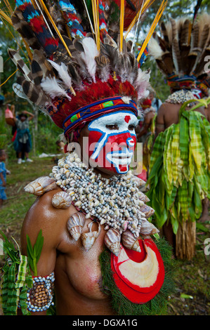 Una donna con il colorfully decorato costume e faccia la vernice è festeggiato presso il tradizionale cantare cantare la raccolta nelle highlands Foto Stock